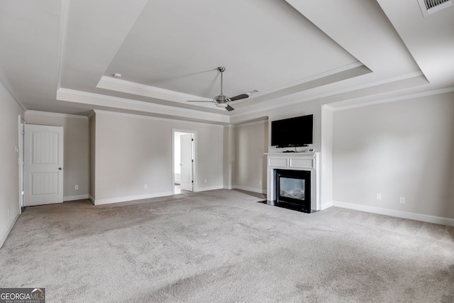 unfurnished living room featuring ceiling fan, a raised ceiling, light carpet, and crown molding