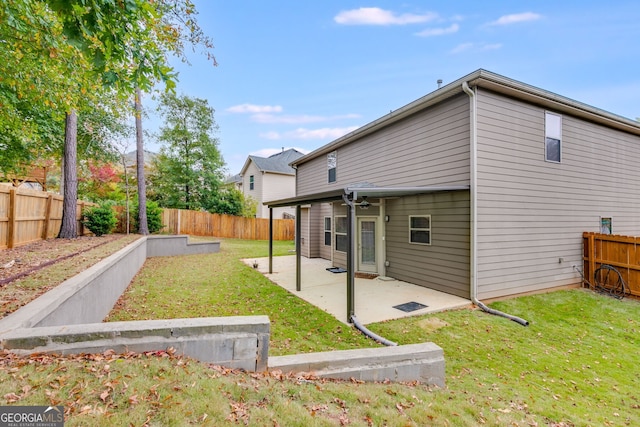 back of house with a patio and a lawn