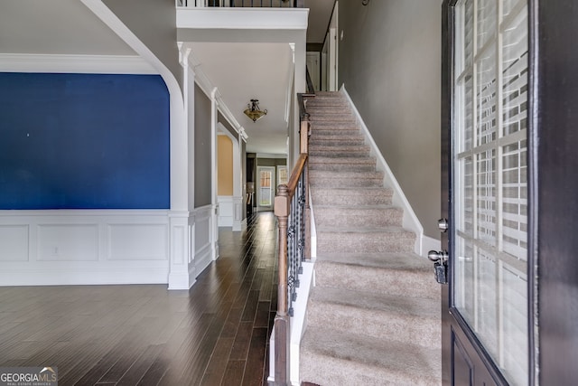 staircase featuring ornamental molding and hardwood / wood-style flooring