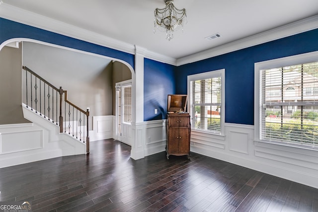 entrance foyer with crown molding, a notable chandelier, and dark hardwood / wood-style floors