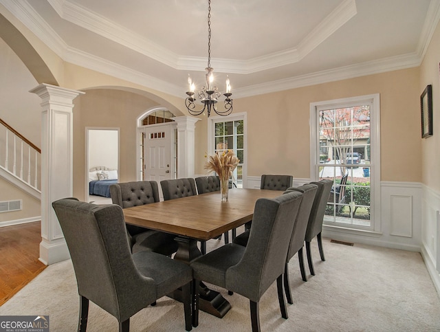 dining space featuring a raised ceiling, crown molding, and a chandelier