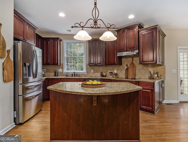 kitchen featuring a center island, decorative light fixtures, light hardwood / wood-style floors, and black appliances