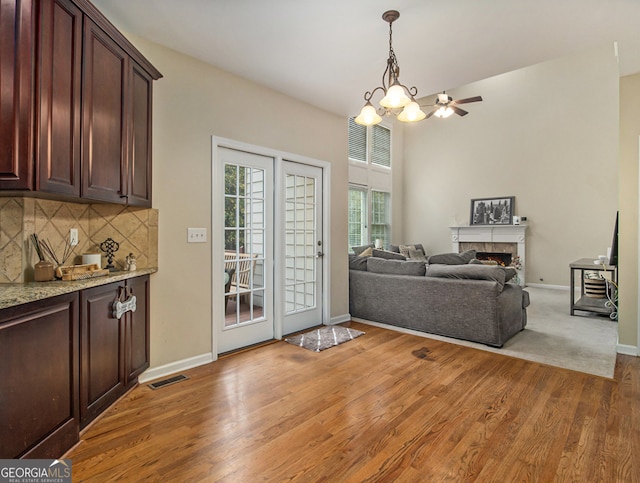 living room with wood-type flooring and ceiling fan with notable chandelier