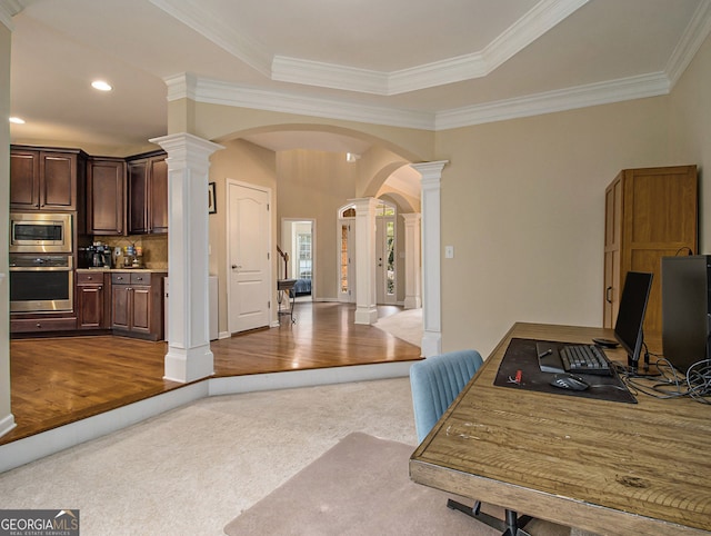 interior space featuring ornate columns, crown molding, and hardwood / wood-style floors