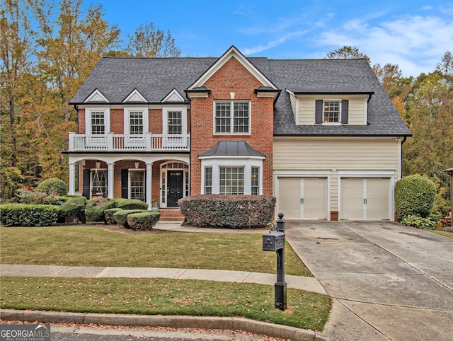 view of front of house featuring a garage, a balcony, and a front yard