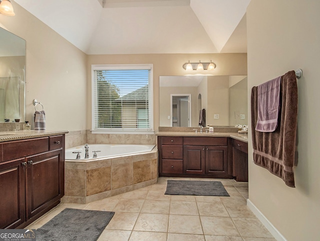 bathroom featuring tile patterned floors, tiled tub, vanity, and lofted ceiling