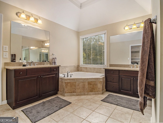 bathroom with tile patterned flooring, vanity, and tiled tub