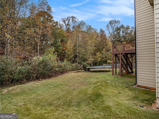 view of yard featuring a deck and a trampoline