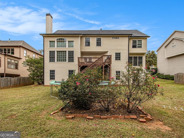 back of house featuring a deck and a yard