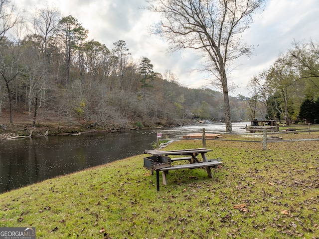 view of home's community featuring a water view and a yard