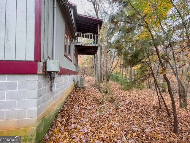 view of side of property with central AC unit and a balcony