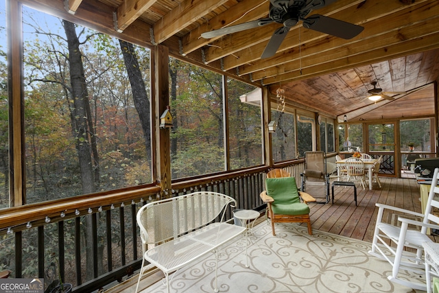 sunroom with lofted ceiling, ceiling fan, wood ceiling, and a healthy amount of sunlight