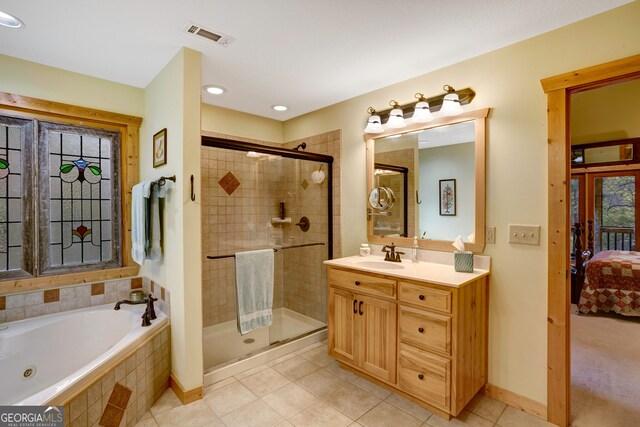 bathroom with tile patterned flooring, vanity, and independent shower and bath