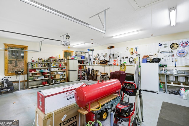 garage featuring a workshop area and white refrigerator