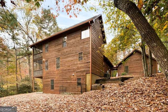 view of side of property with a sunroom and central AC unit