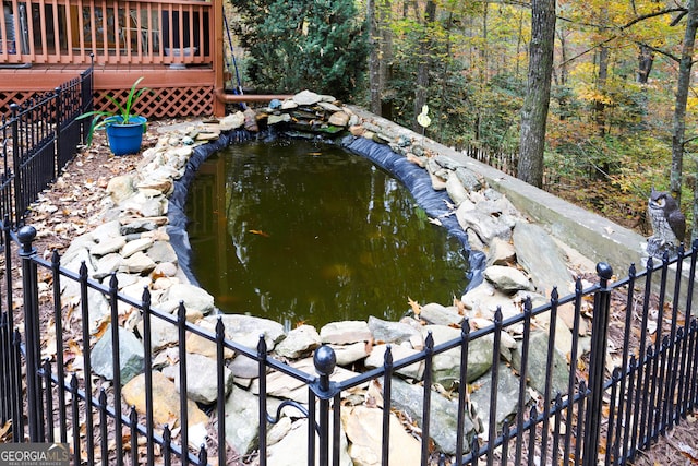 view of swimming pool featuring a deck and a garden pond