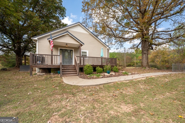 view of front of home with a front yard and a deck