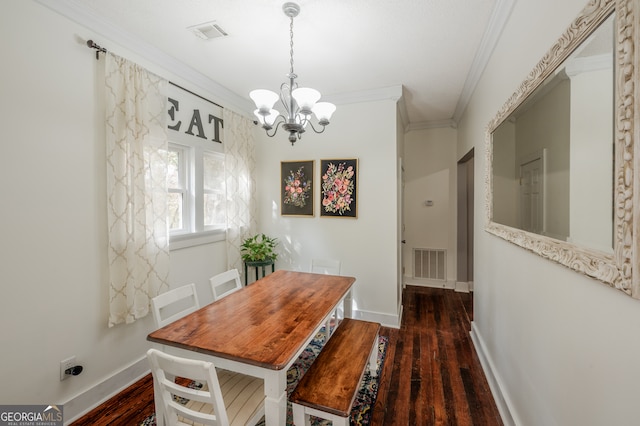 dining space with ornamental molding, dark wood-type flooring, and an inviting chandelier