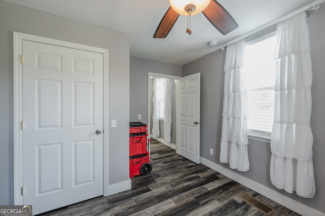 interior space with ceiling fan, plenty of natural light, and dark hardwood / wood-style floors