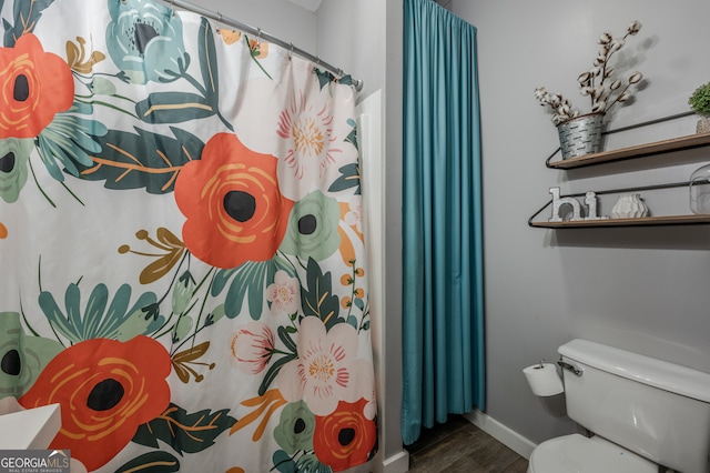 bathroom featuring hardwood / wood-style floors, a shower with shower curtain, and toilet