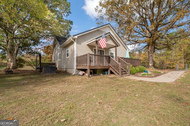 view of front facade featuring a front lawn and a wooden deck