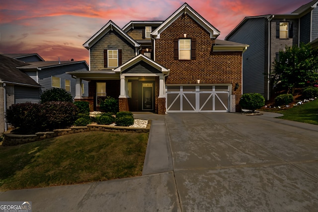 view of front of house with a porch, a garage, and a lawn