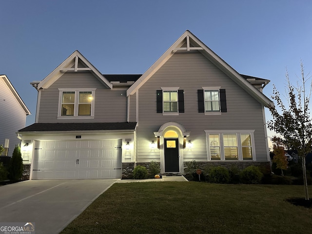 view of front of home with a garage and a lawn