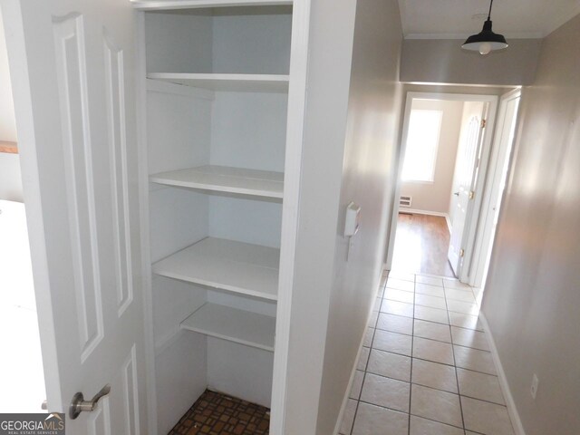 spare room with baseboards, dark wood-type flooring, visible vents, and crown molding