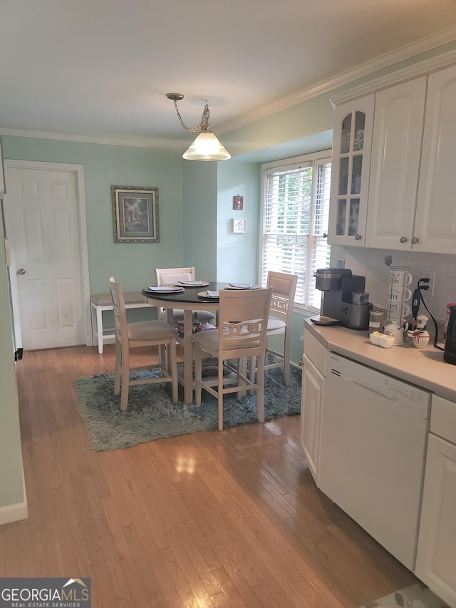 dining area with light hardwood / wood-style flooring and crown molding