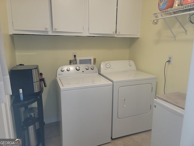 washroom with washer and dryer, light tile patterned flooring, and cabinets