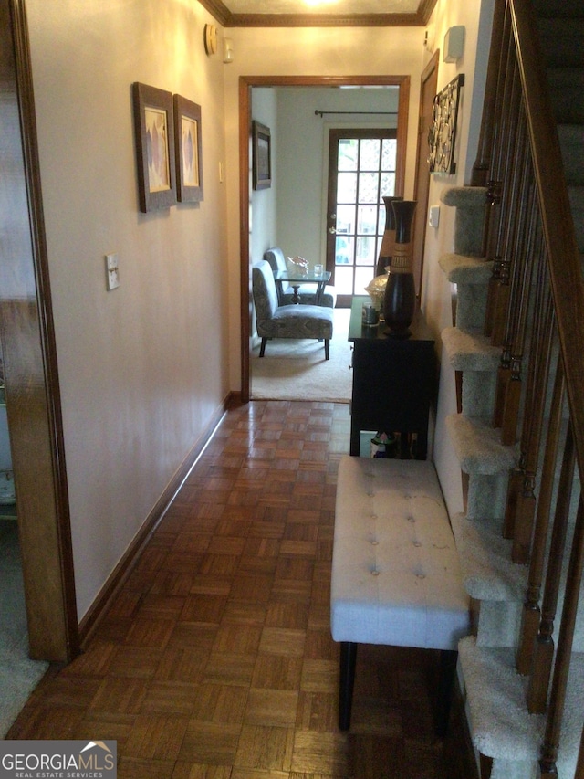 hallway with dark parquet flooring and crown molding