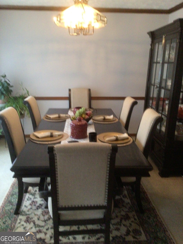 carpeted dining room with a chandelier and ornamental molding