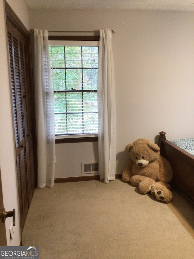 carpeted bedroom featuring a textured ceiling and multiple windows