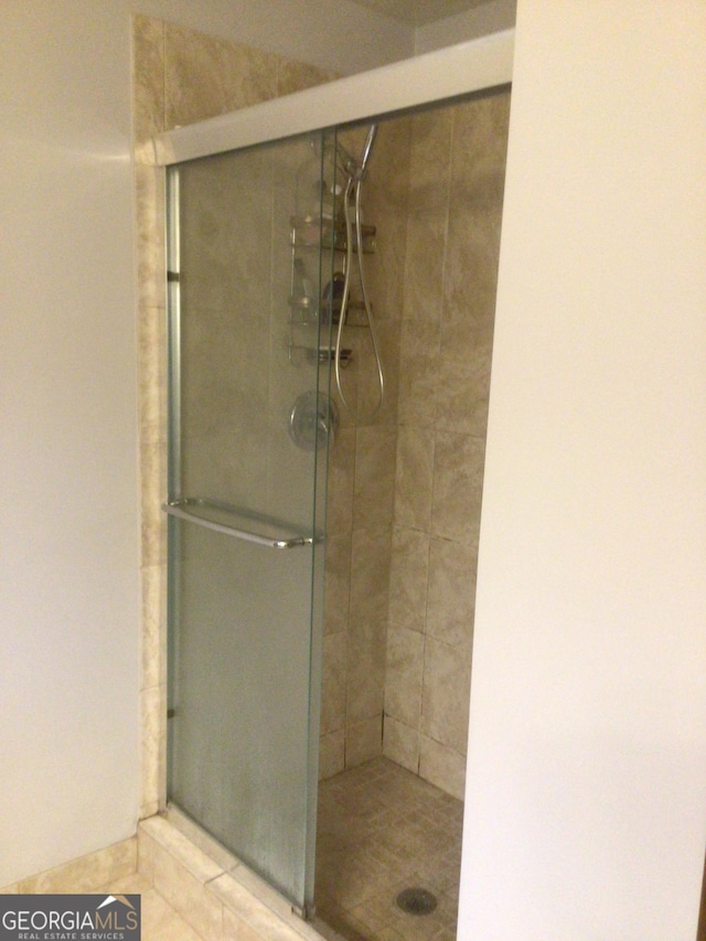 bathroom featuring tile patterned flooring and a shower with door