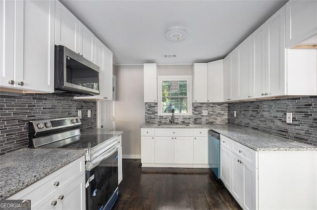 kitchen with dark hardwood / wood-style flooring, white cabinetry, sink, and appliances with stainless steel finishes