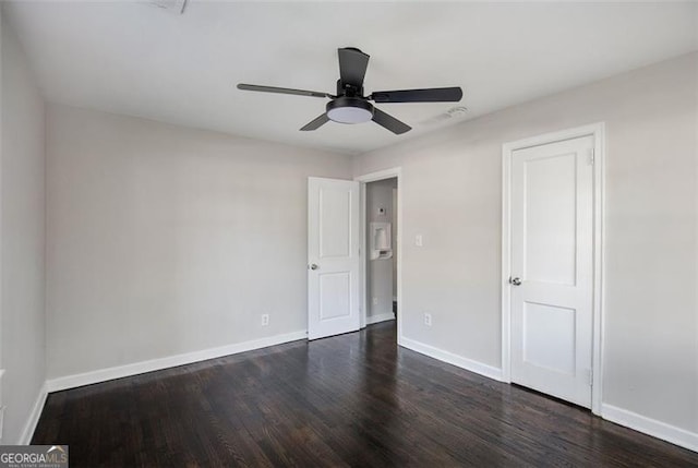 unfurnished bedroom featuring ceiling fan and dark hardwood / wood-style flooring