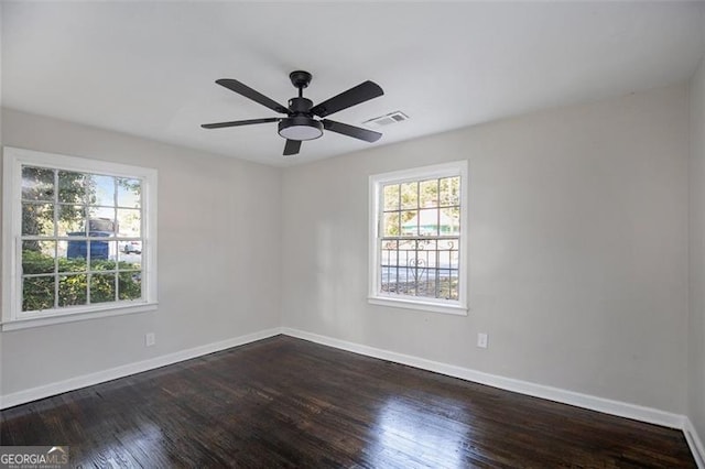 unfurnished room with ceiling fan and dark wood-type flooring