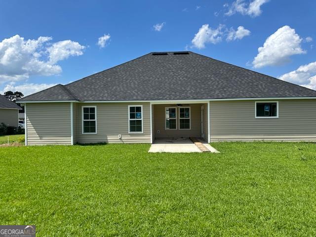 back of property featuring a patio and a lawn