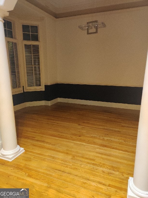 unfurnished room with hardwood / wood-style floors and ornamental molding