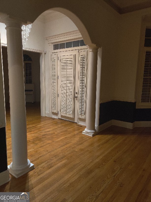 empty room with hardwood / wood-style floors and a notable chandelier