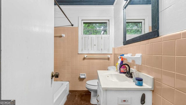 full bathroom featuring shower / bathtub combination, vanity, hardwood / wood-style flooring, tile walls, and toilet