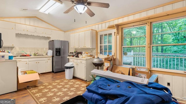 kitchen with white cabinetry, stainless steel fridge with ice dispenser, light hardwood / wood-style floors, and lofted ceiling