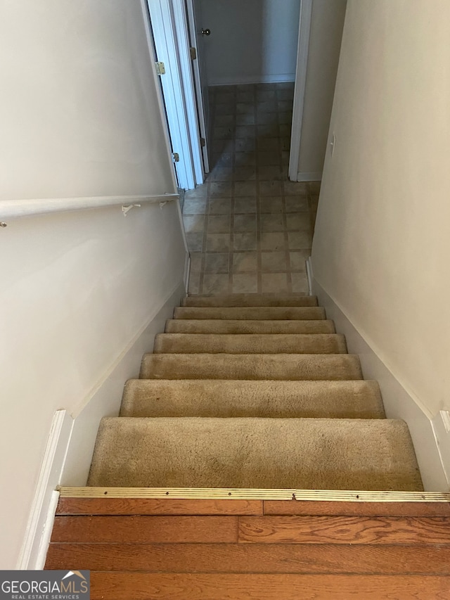 staircase featuring tile patterned floors