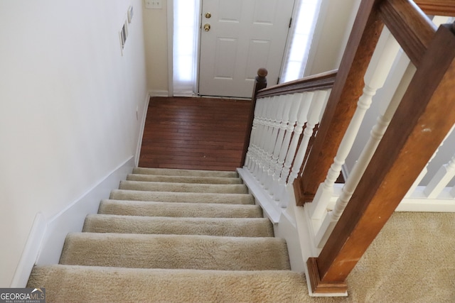 stairs featuring hardwood / wood-style floors