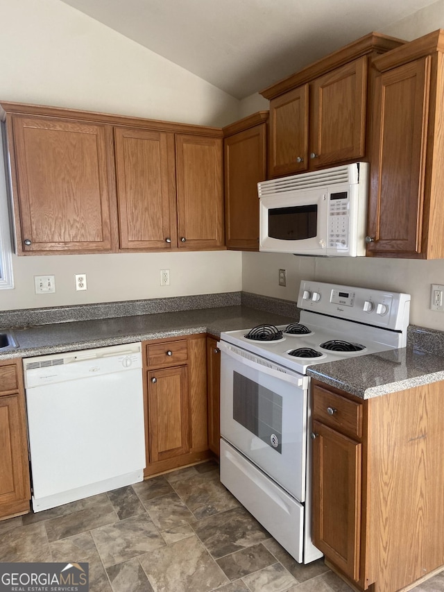 6995 Pine Shadow Way, Winston, GA 30187 - kitchen featuring white appliances, lofted ceiling, stone finish floors, brown cabinets, and dark countertops