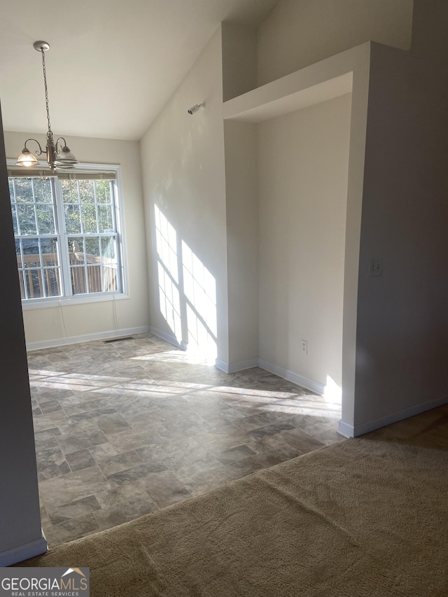 6995 Pine Shadow Way, Winston, GA 30187 - empty room with a chandelier, stone finish floors, and lofted ceiling
