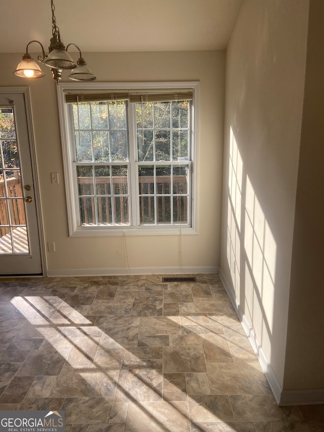 unfurnished dining area featuring an inviting chandelier