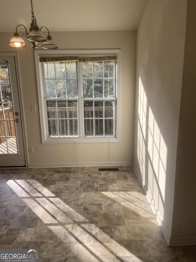 6995 Pine Shadow Way, Winston, GA 30187 - unfurnished dining area featuring stone finish floors, plenty of natural light, and a chandelier