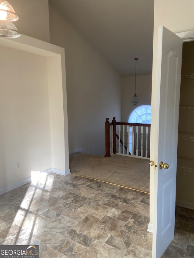 hall with carpet and lofted ceiling