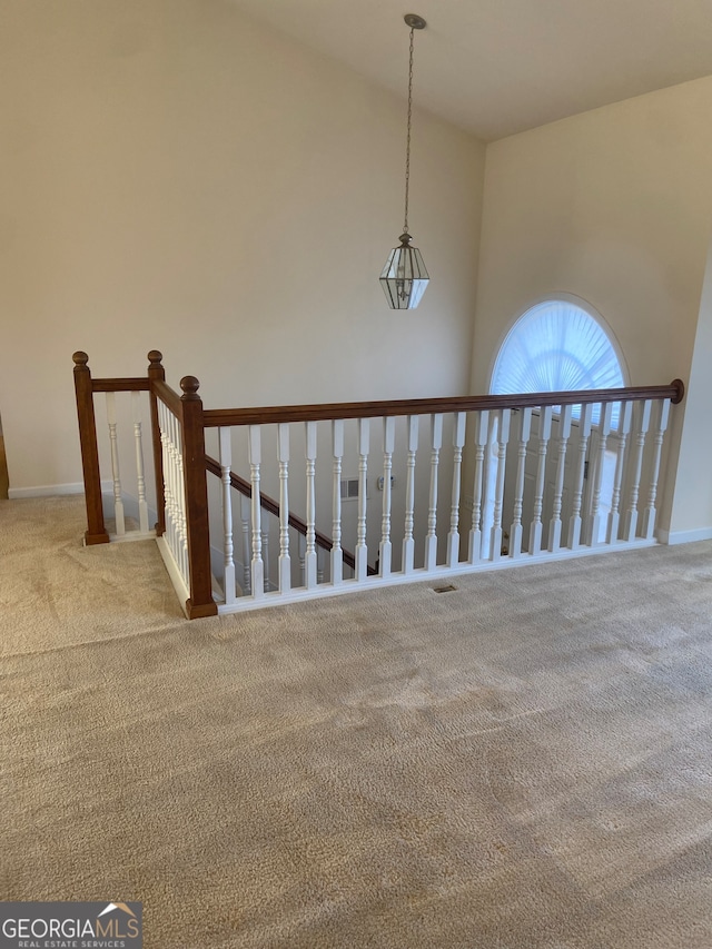 staircase with carpet floors and high vaulted ceiling